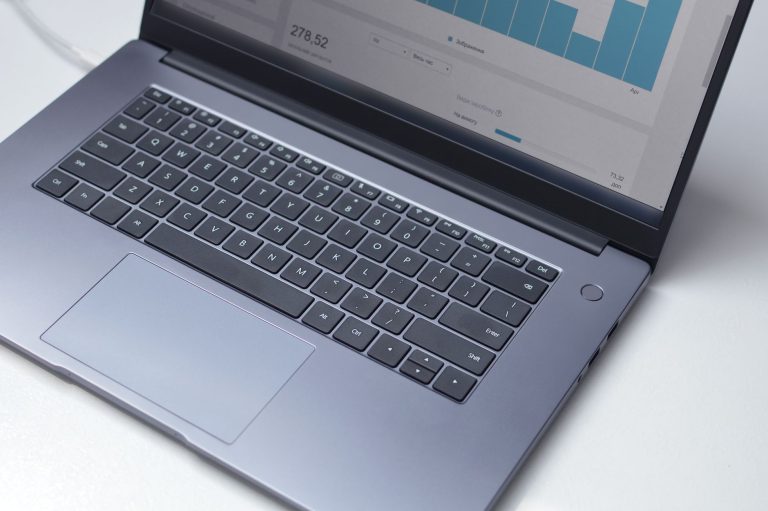 Ноутбук на столі з відкритою CRM-панеллю та графіками продажів