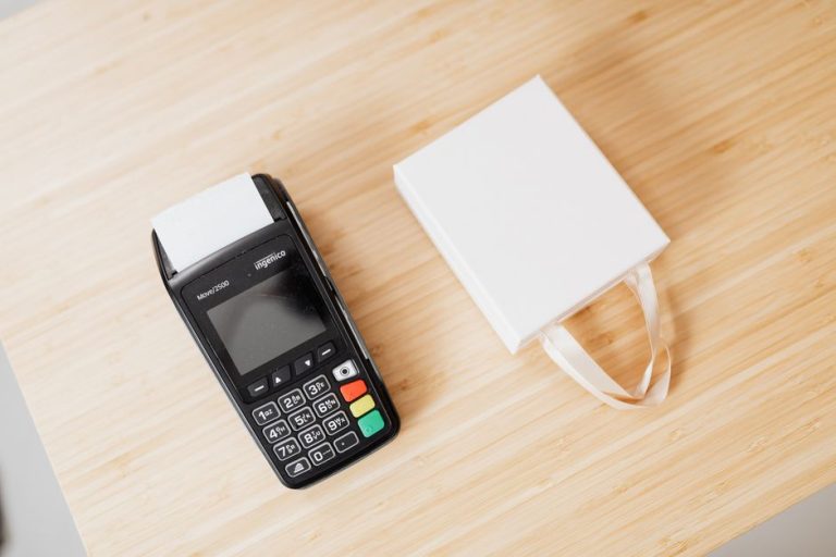 Платіжний термінал і подарунковий пакет на прилавку - утримання клієнтів у бізнесі